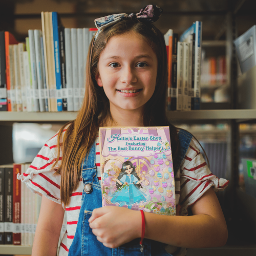 happy-little-girl-holding-a-book-mockup-at-the-library-a19273 (1)-min