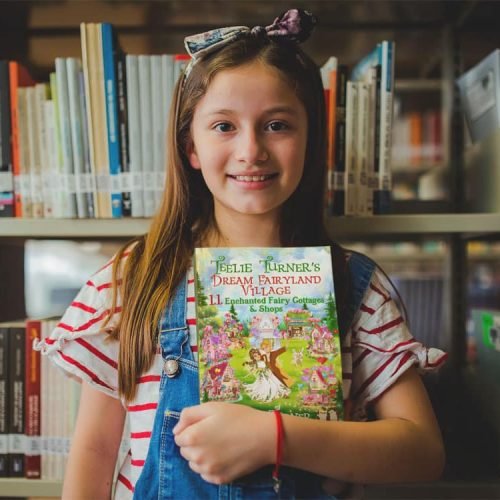 happy-little-girl-holding-a-book-mockup-at-the-library-a19273 happy-little-girl-holding-a-book-mockup-at-the-library-a19273