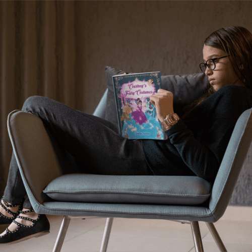 kid-reading-a-book-mockup-sitting-on-a-vintage-armchair-a19075-min-min