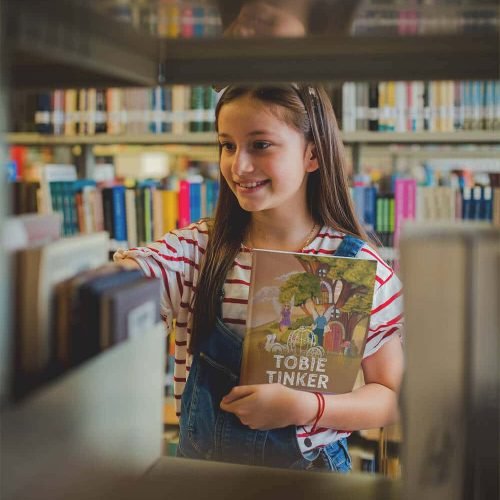 smiling-girl-holding-a-book-template-at-a-library-a19275-(1) (1)